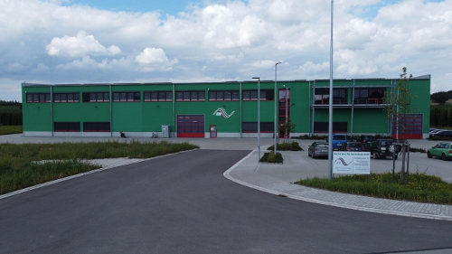 Aussenansicht des Firmengebäudes von ID-Lindner GmbH, grünes Gebäude, Zufahrt von der Straße